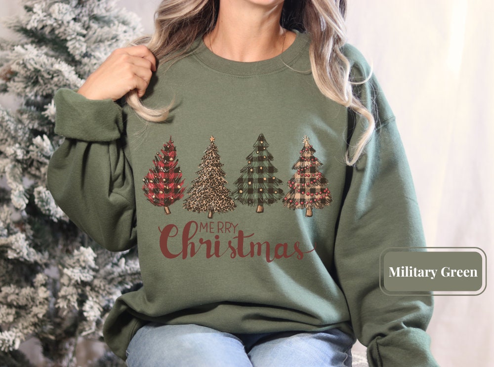 Military green Christmas sweatshirt with decorated trees and 'Merry Christmas' script. Ideal holiday sweatshirt, Christmas tree shirt, and winter sweatshirt for festive events. Perfect for Christmas squad and holiday xmas shirt lovers.