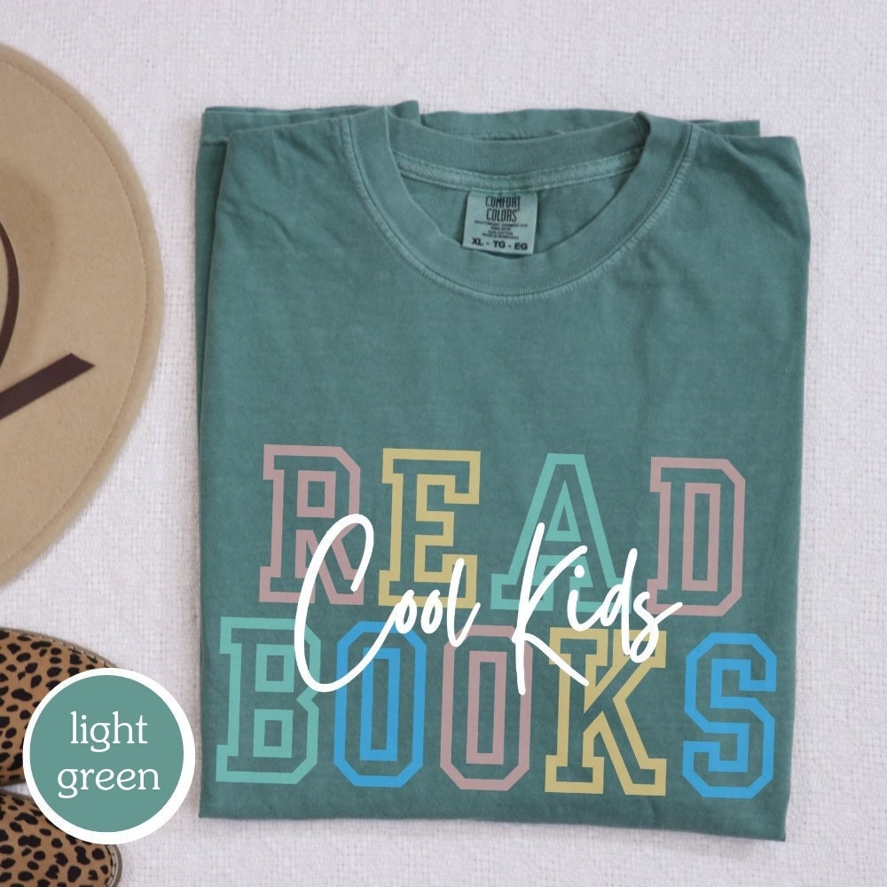 Comfort Colors t-shirt in light green with "cool kids read books" design. Perfect gift for book lovers, teachers, and book clubs. Ideal for trendy literary shirts and teacher appreciation gifts.