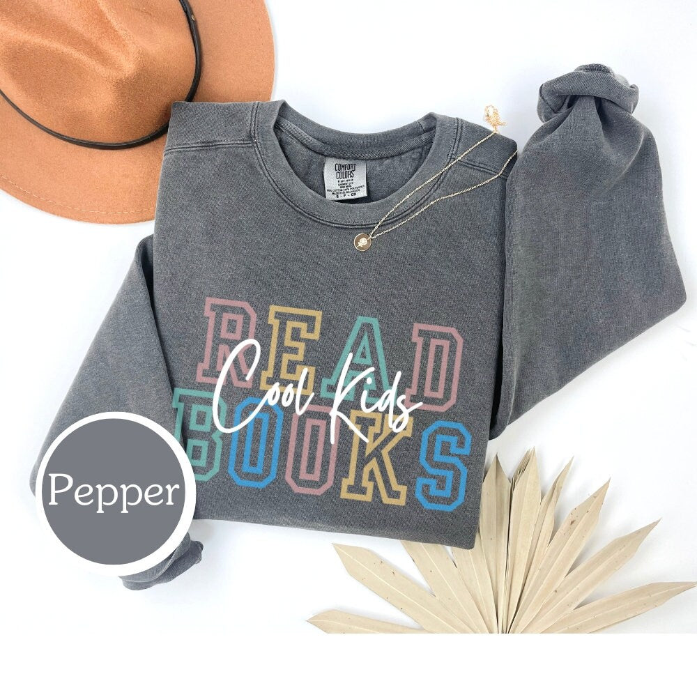 Comfort Colors sweatshirt in Pepper with "cool kids read books" design. Ideal for book lovers, teachers, and book clubs. Perfect for trendy literary shirts and teacher appreciation gifts.