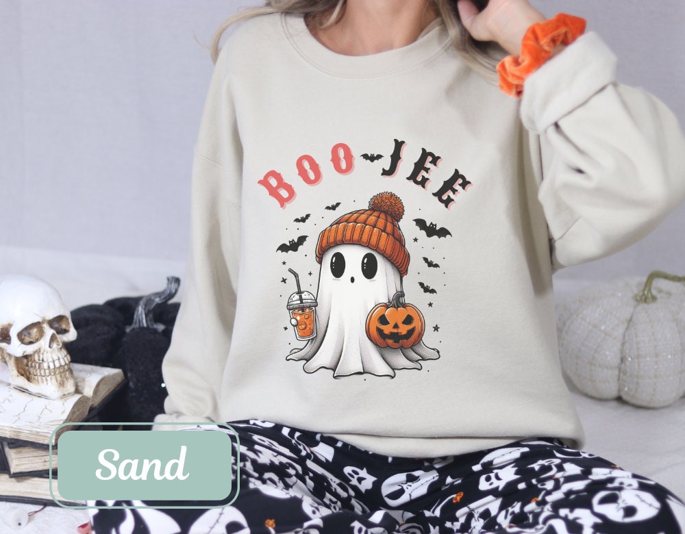 Sand-colored Halloween sweatshirt with &#39;Boo Jee&#39; design, showcasing a ghost with a pumpkin and coffee. This spooky shirt is perfect for fall, cool Halloween shirt lovers, ghost crewnecks, and Halloween parties. Great mom, grandma, and teacher gift.