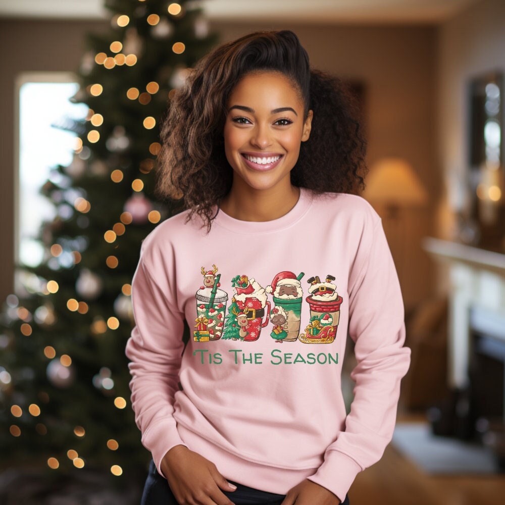 Brighten your holidays with this pink Christmas sweatshirt. Adorned with Black Santa and festive characters, ideal for a cozy Christmas crewneck or teacher shirt.