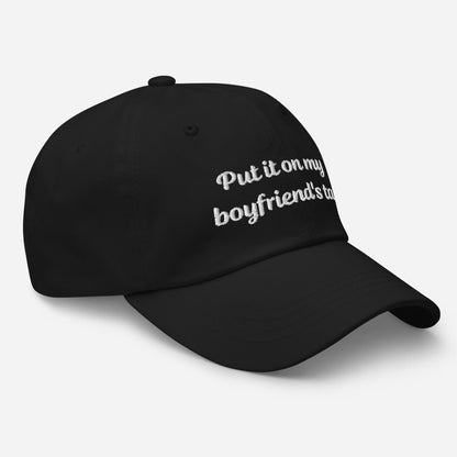 A stylish black dad hat with embroidered text, &quot;Put it on my boyfriend&#39;s tab,&quot; perfect as a funny gift for your girlfriend. This sarcasm-infused baseball cap adds an aesthetic touch to any outfit.