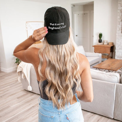 A stylish black dad hat with embroidered text, &quot;Put it on my boyfriend&#39;s tab,&quot; perfect as a funny gift for your girlfriend. This sarcasm-infused baseball cap adds an aesthetic touch to any outfit.