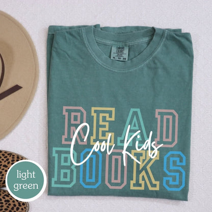 Comfort Colors t-shirt in light green with &quot;cool kids read books&quot; design. Perfect gift for book lovers, teachers, and book clubs. Ideal for trendy literary shirts and teacher appreciation gifts.