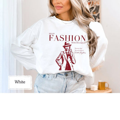 White sweatshirt with &#39;Killer Fashion Detective Skills&#39; design in red, ideal for chilly days. Perfect for fans of true crime, murder shows, and detective stories. Cozy and stylish for casual wear or as a unique gift.