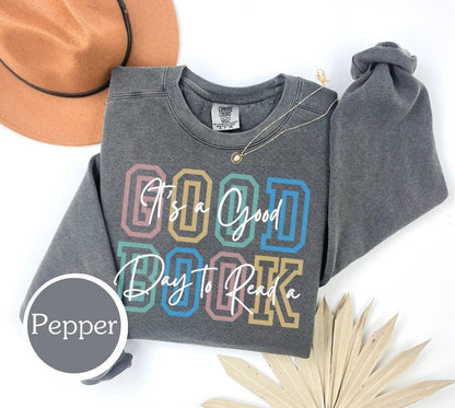 Comfort Colors sweatshirt in pepper with &#39;It’s a Good Day to Read a Book&#39; design. Ideal for book lovers, teachers, and book clubs. Perfect for trendy literary shirts and teacher appreciation gifts.