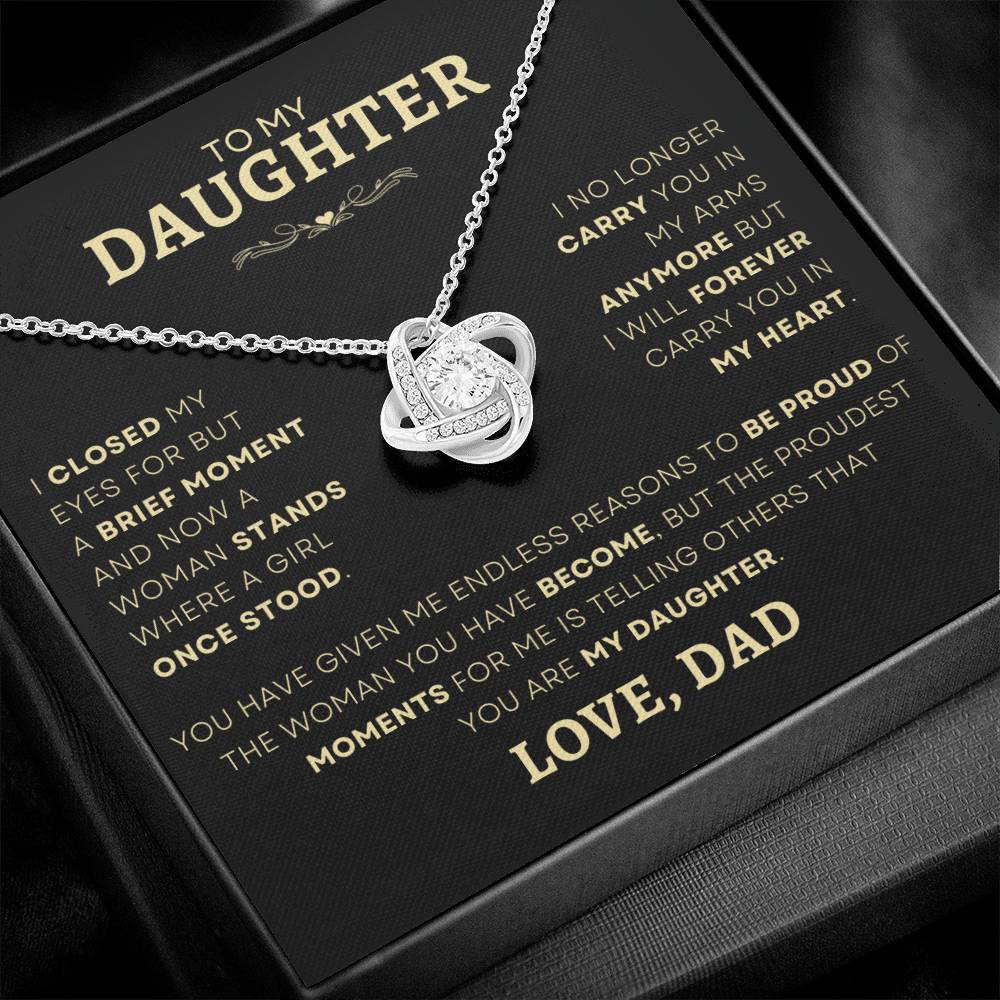 Close-up of a Love Knot Necklace with a sparkling cubic zirconia center, a special jewelry gift from father to daughter, displayed on a heartfelt message card in a luxurious box.