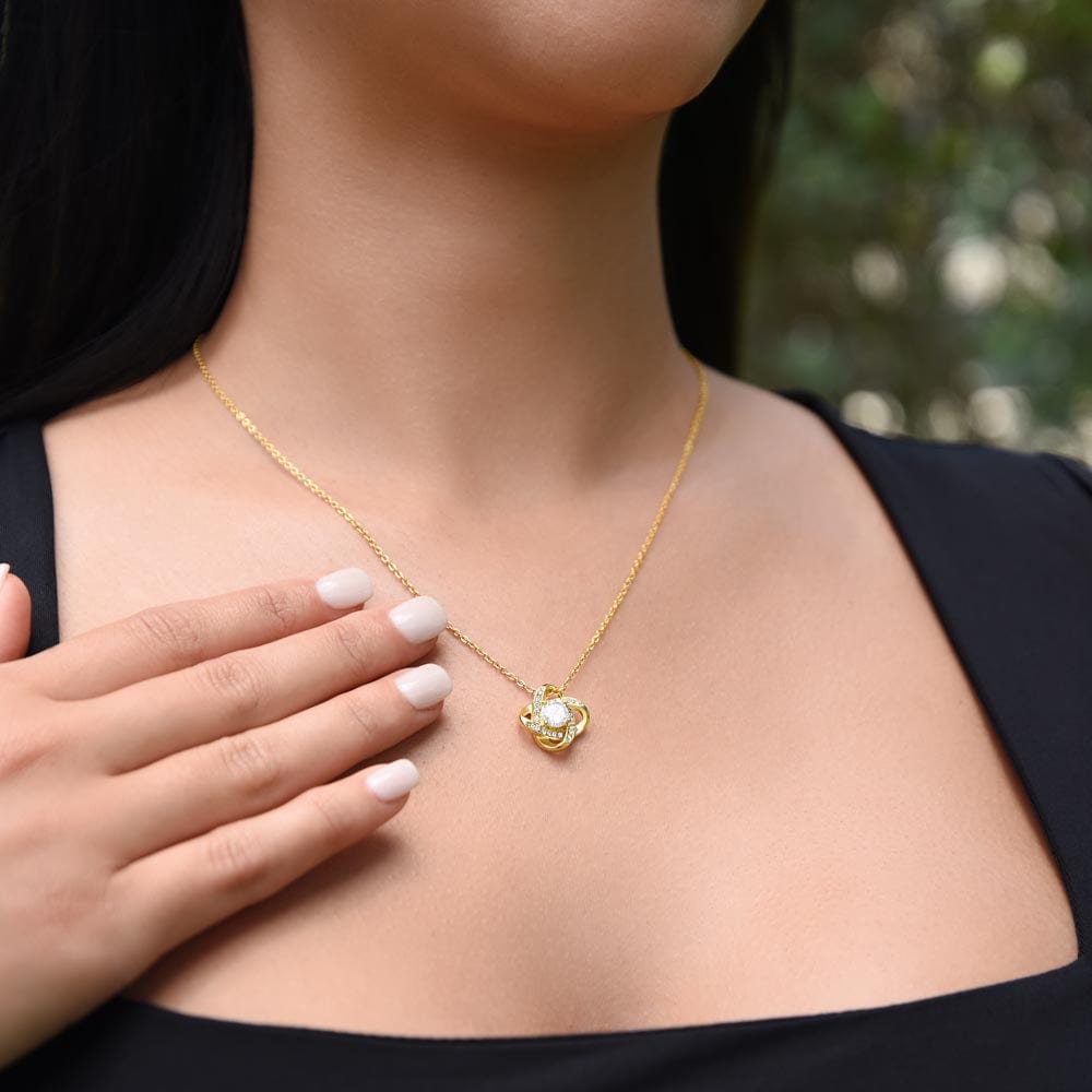 Elegant woman wearing a Love Knot Daughter's Necklace in gold finish, a thoughtful gift from father to daughter, exemplifying timeless love and connection.