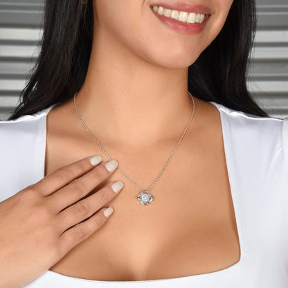 Smiling woman showcasing a sparkling Love Knot Necklace, an ideal gift for daughters to signify a father's enduring love and connection.