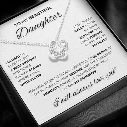 Silver Love Knot Daughter's Necklace with a heartfelt message card in a display case, a captivating gift from a father symbolizing love and pride.